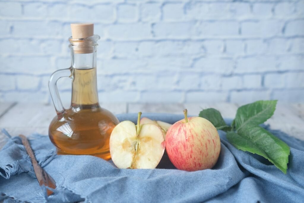 Apple cider vinegar bottle with fresh apples health and wellness