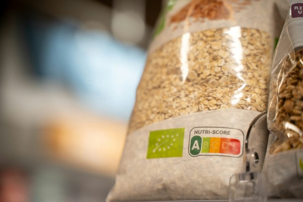 Person reading nutrition label on food packaging in supermarket